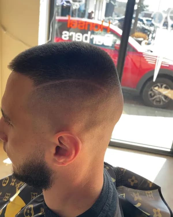 Donkere skin fade met scheiding en baard