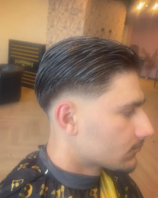 Donker haar naar achteren gekamd met fade