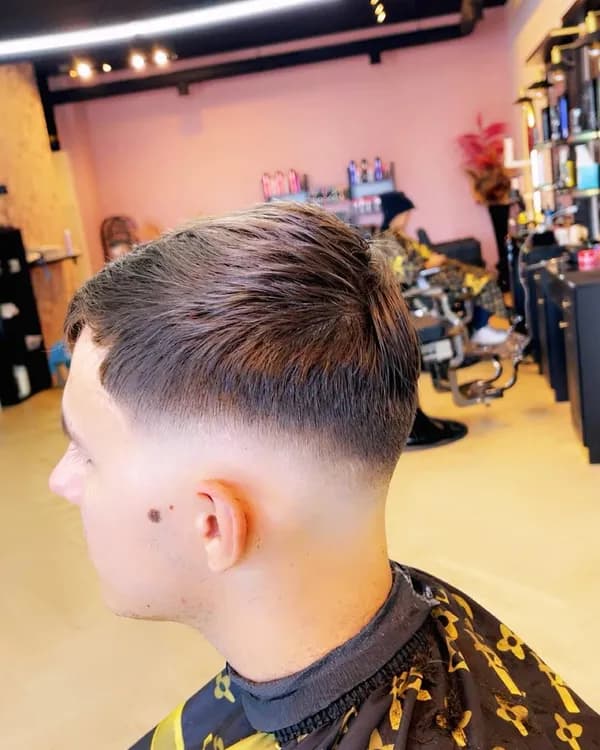 Donker haar met zijscheiding en fade